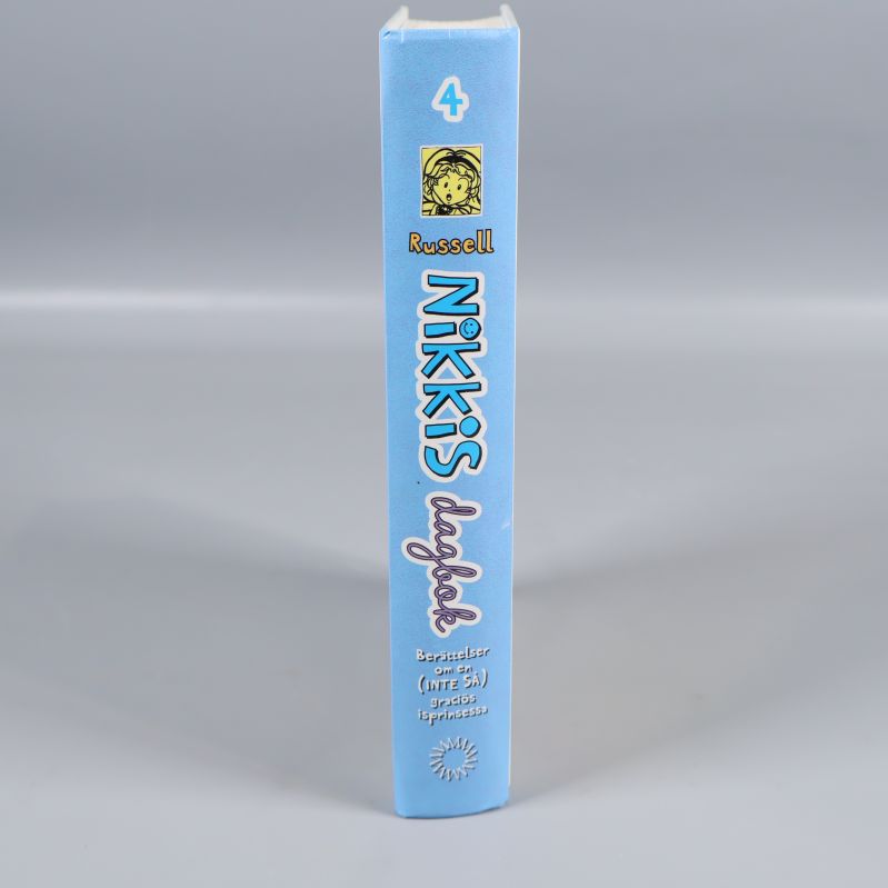 Bokens rygg med texten Nikkis dagbok #4 och illustration