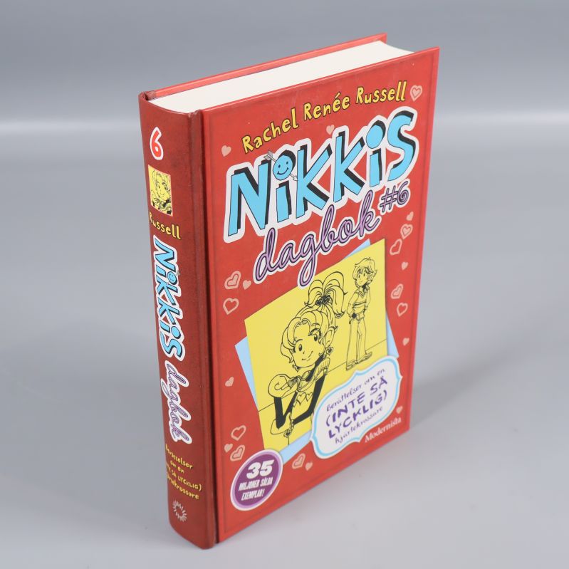 Nikkis dagbok #6 fotografi i vinkel, visar ryggen och framsidan