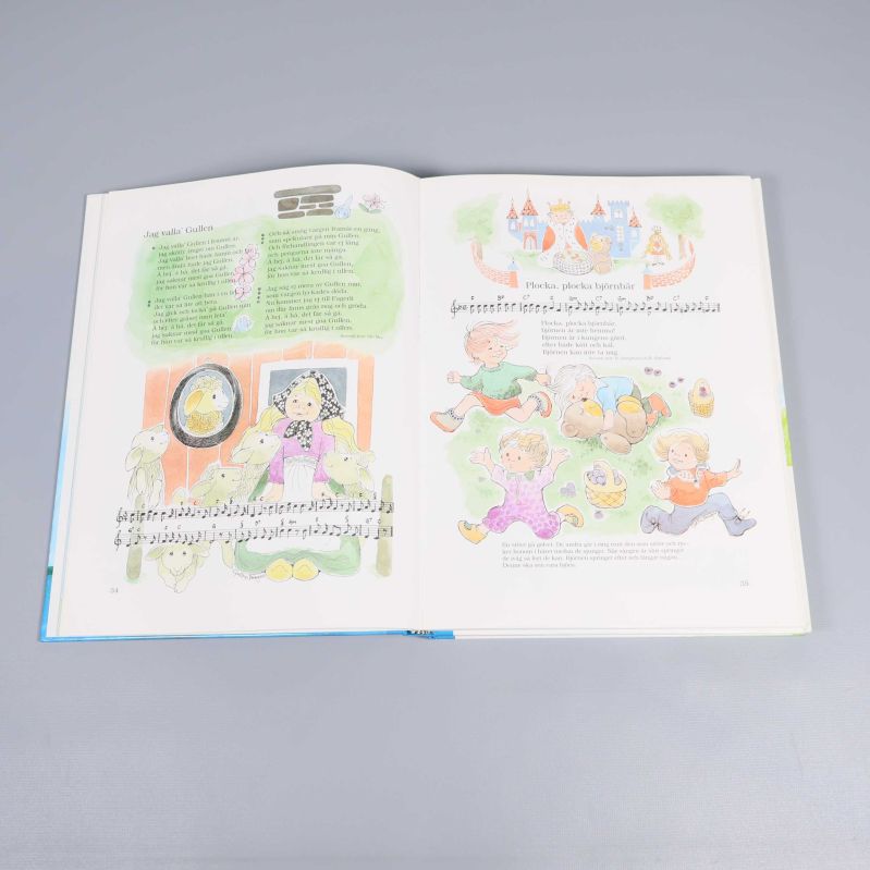 Uppslag ur barnbok med noter, texter och färgglada illustrationer