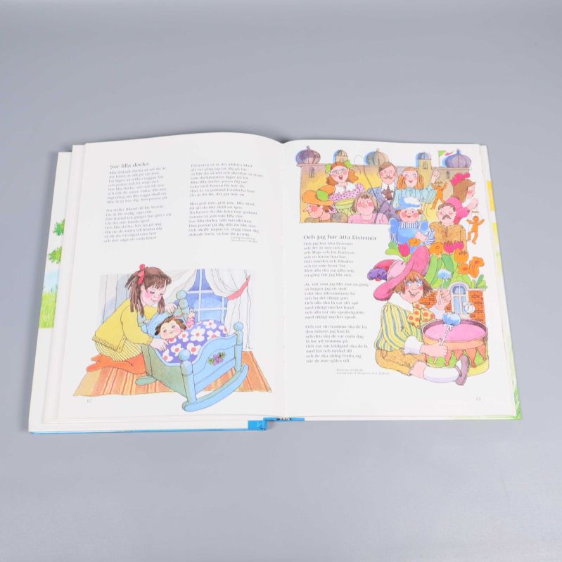 Uppslag med sagotexter och en mamma som vyssjar barn i säng samt stor grupp barn vid festligt bord