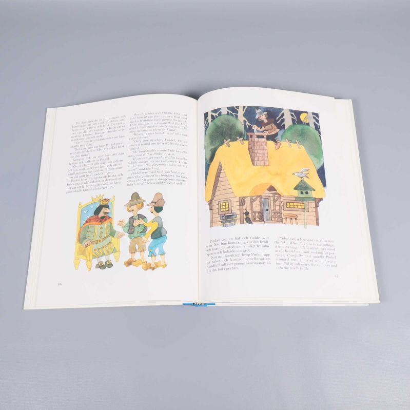 Uppslaget ur Guldäpple med silverblad med färgillustrationer och svensk text