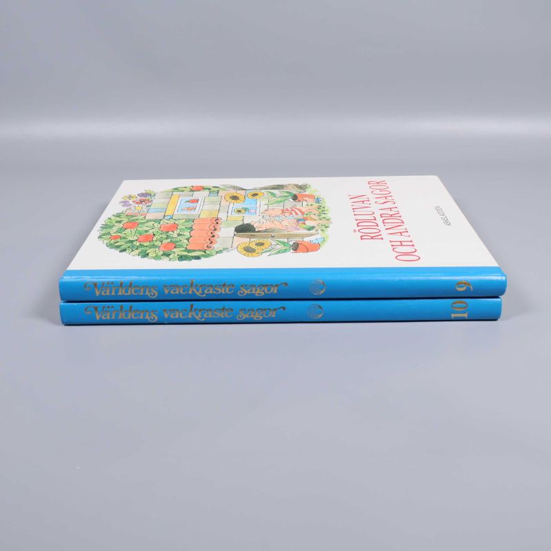 Sagoböcker staplade, blå ryggar med guldtext synliga