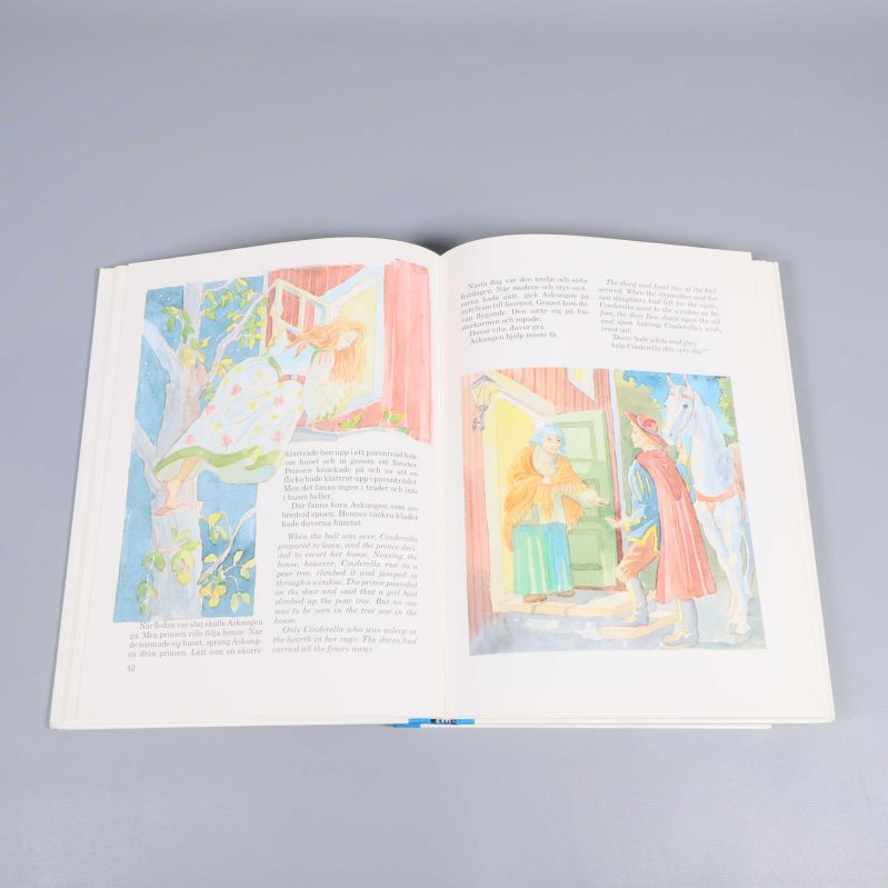 Uppslag ur sagobok med akvarellillustrationer och text