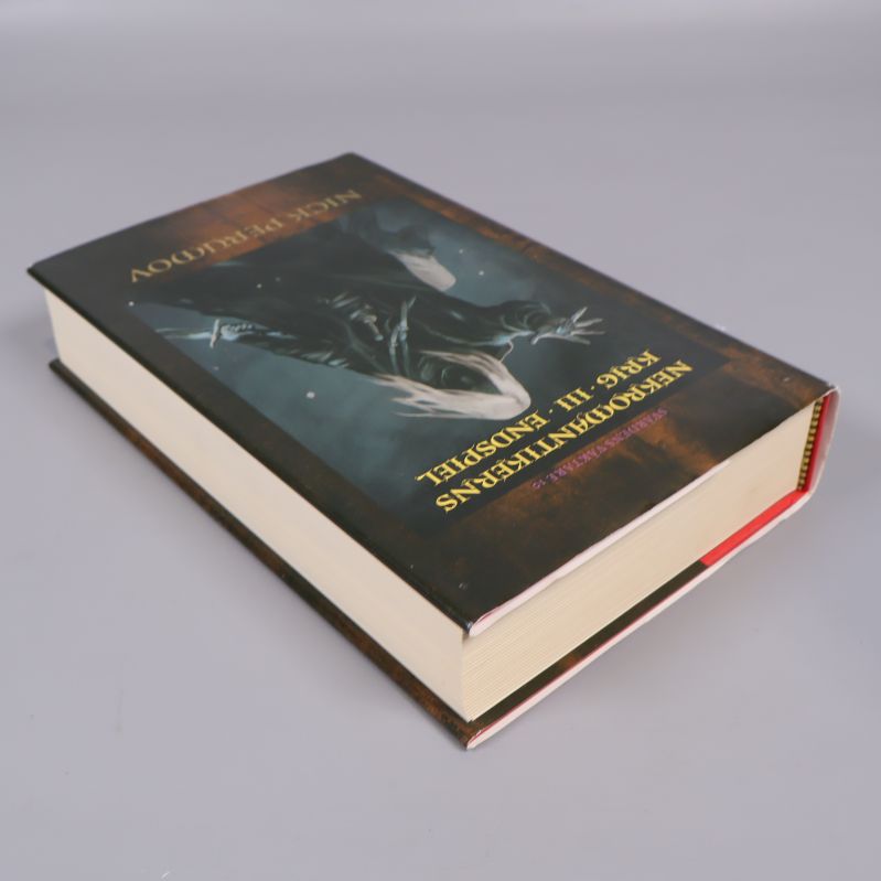 Boken liggande på sidan, visar tjocklek och hårda pärmar