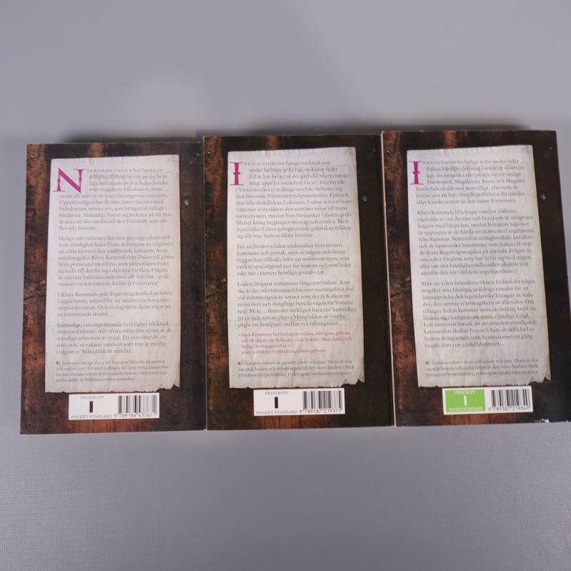 Baksidor med sammanfattningar och streckkoder för tre böcker