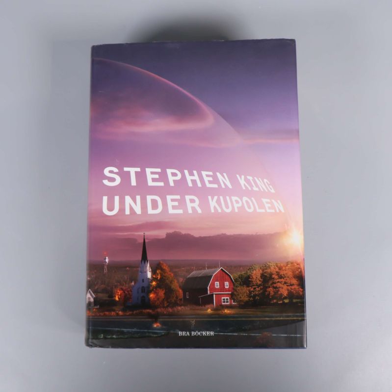 Omslaget till Under kupolen av Stephen King med landskap och lila himmel