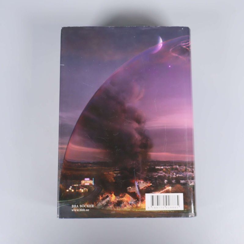 Baksidan av boken Under kupolen med illustration av kupol över stad och streckkod