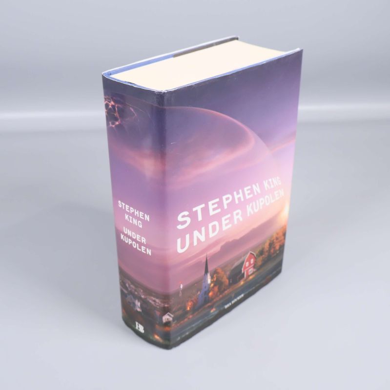 Boken Under kupolen av Stephen King stående med synlig rygg och omslag