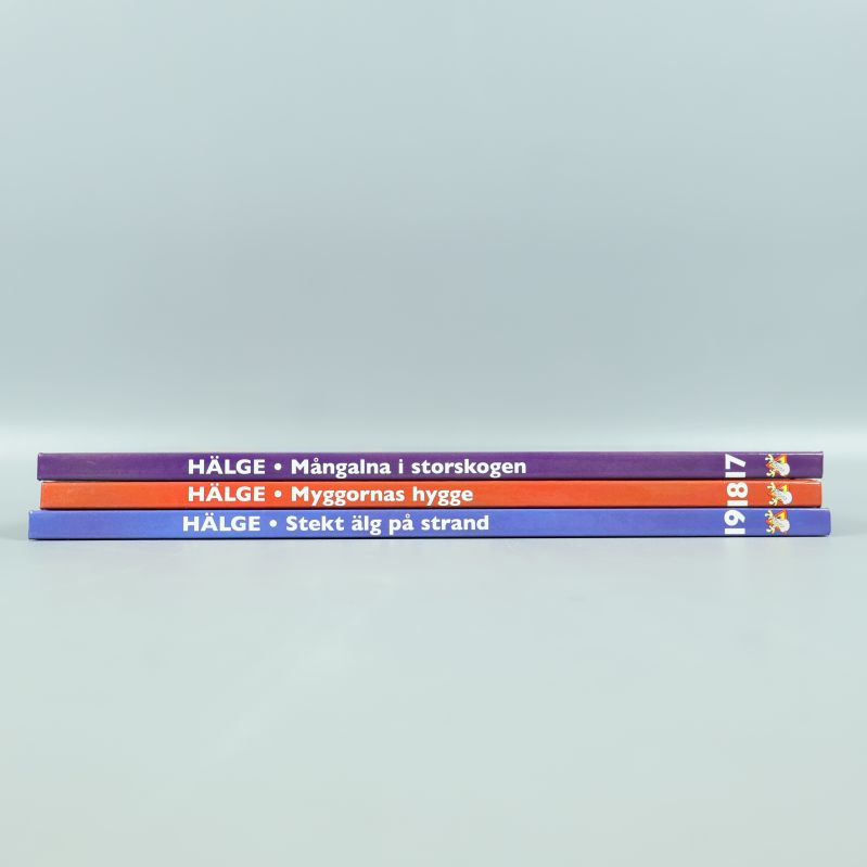 Tre Hälge böcker staplade med synliga ryggar och titlar