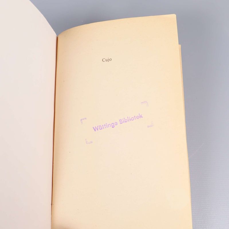 Sida med titeln Cujo och stämpel från Wättinge Bibliotek