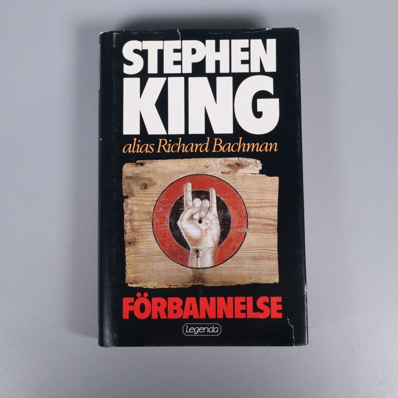 Omslag på Förbannelse av Stephen King, svart bakgrund och handsymbol