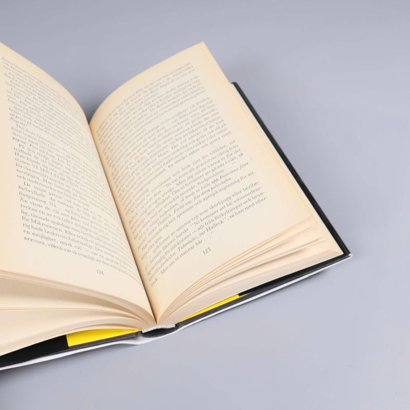 Närbild på öppnad bok Förbannelse, sidorna 124 och 125, text synlig