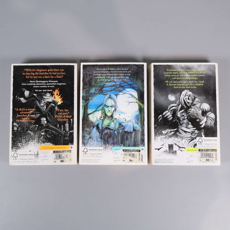 Baksidor av tre Skulduggery Pleasant-böcker med svartvita illustrationer