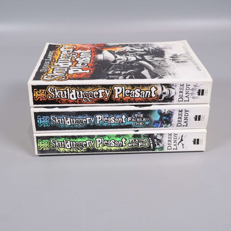 Bokryggar på tre Skulduggery Pleasant-böcker staplade i profil