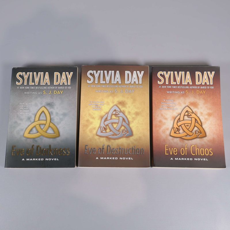 Tre böcker av Sylvia Day ur Marked-serien med titlarna Eve of Darkness, Eve of Destruction och Eve of Chaos, omslag med olika färgtoner och symbol.