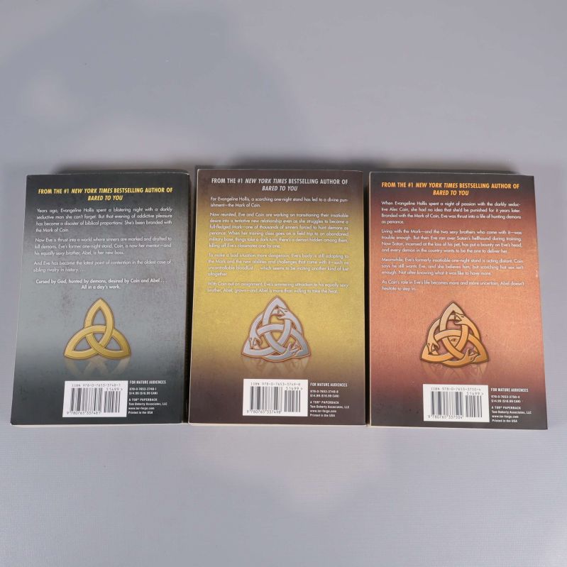 Baksidor av tre Sylvia Day-böcker ur Marked-serien, inklusive beskrivningar samt symbol och ISBN-nummer längst ned.