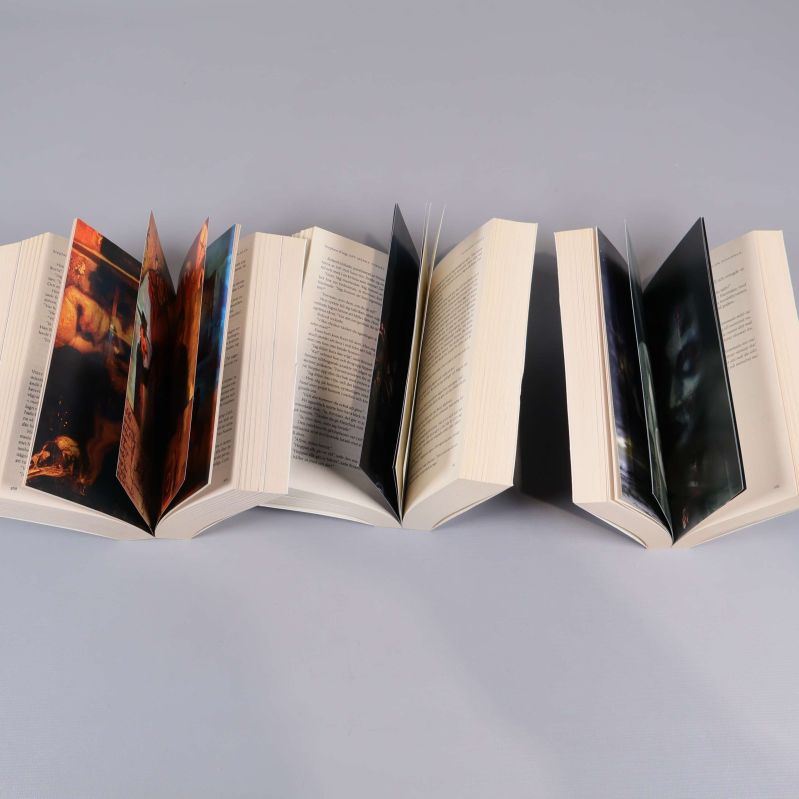 Uppslagna sidor ur tre böcker med illustrationer och text