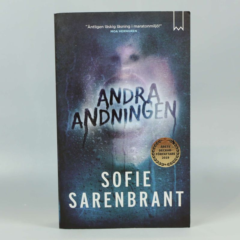 Framsidan på boken Andra andningen av Sofie Sarenbrant med mörkt omslag och titel i centrum