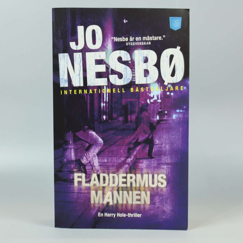 Framsidan av Fladdermusmannen med Jo Nesbøs namn och stadsmotiv i lila