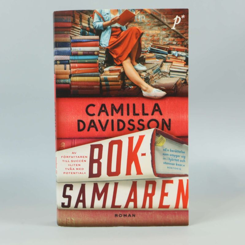 Framsidan av Boksamlaren av Camilla Davidsson, färgstark design med böcker och person