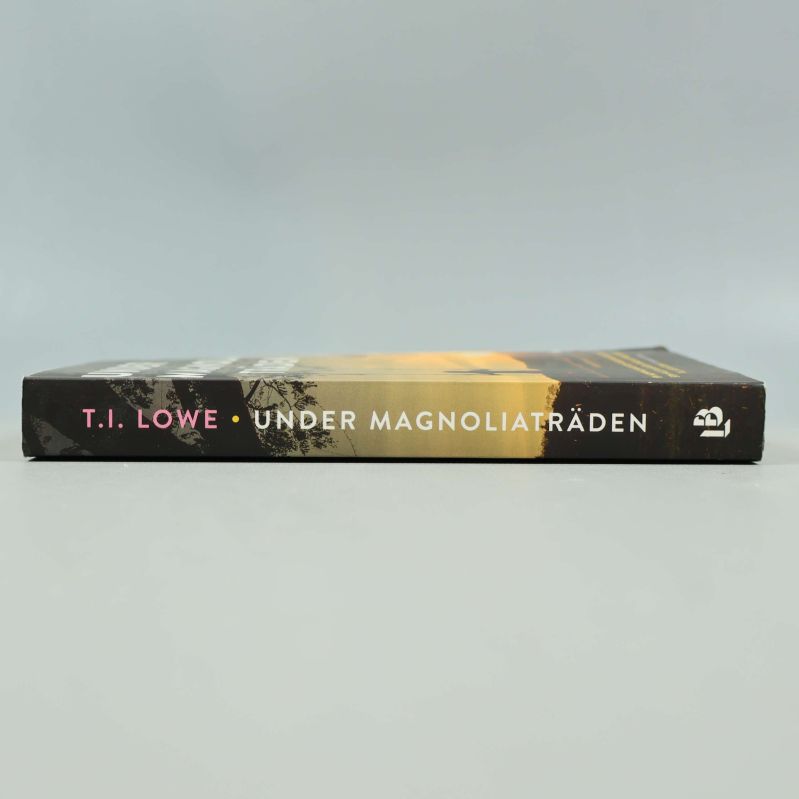 Bokrygg Under magnoliaträden med titel och författare T.I. Lowe