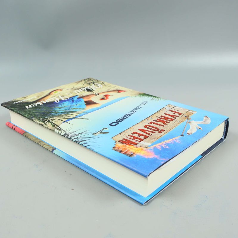 Boken Fyrklövern liggande, visar pärm och sidor