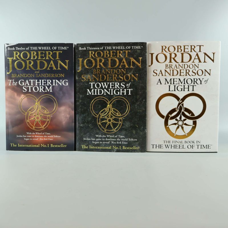 Tre inbundna böcker i serien The Wheel of Time med gulddetaljer på omslagen