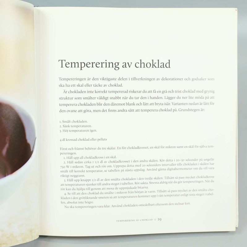 Uppslag med instruktion om temperering av choklad samt recepttext