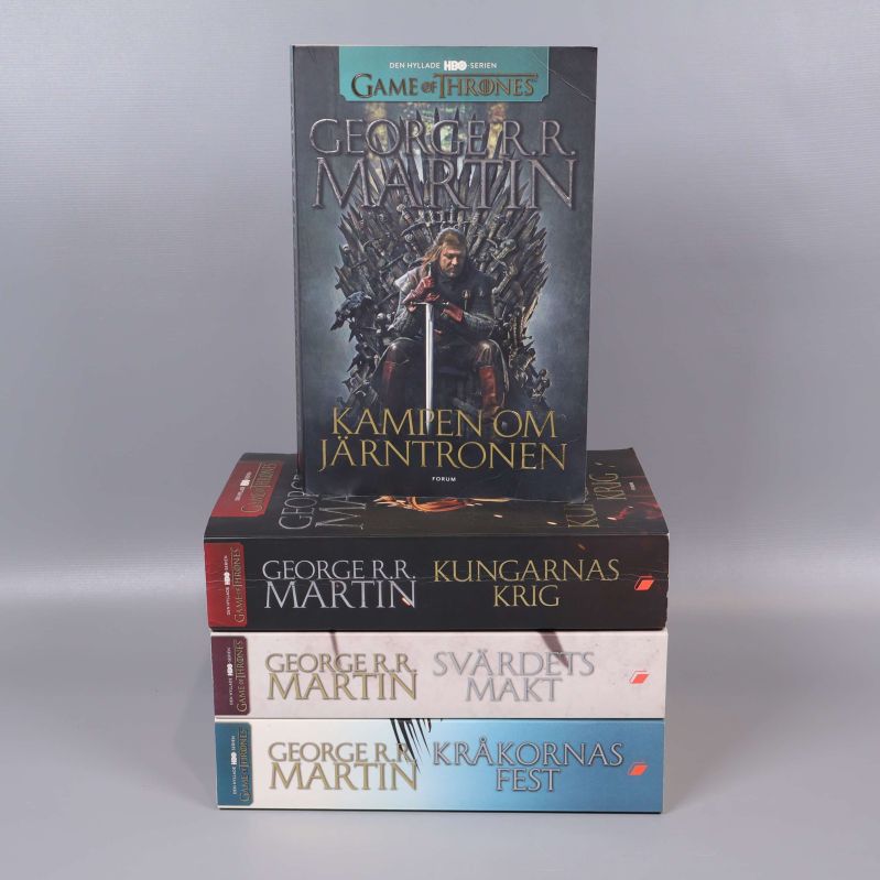 Fyra Game of Thrones-böcker staplade med synliga omslag