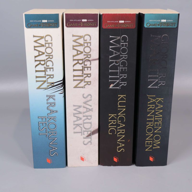 Ryggar av fyra Game of Thrones-böcker på rad