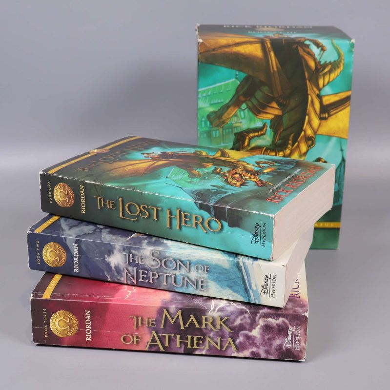 Tre böcker ur The Heroes of Olympus, liggande framför boxen