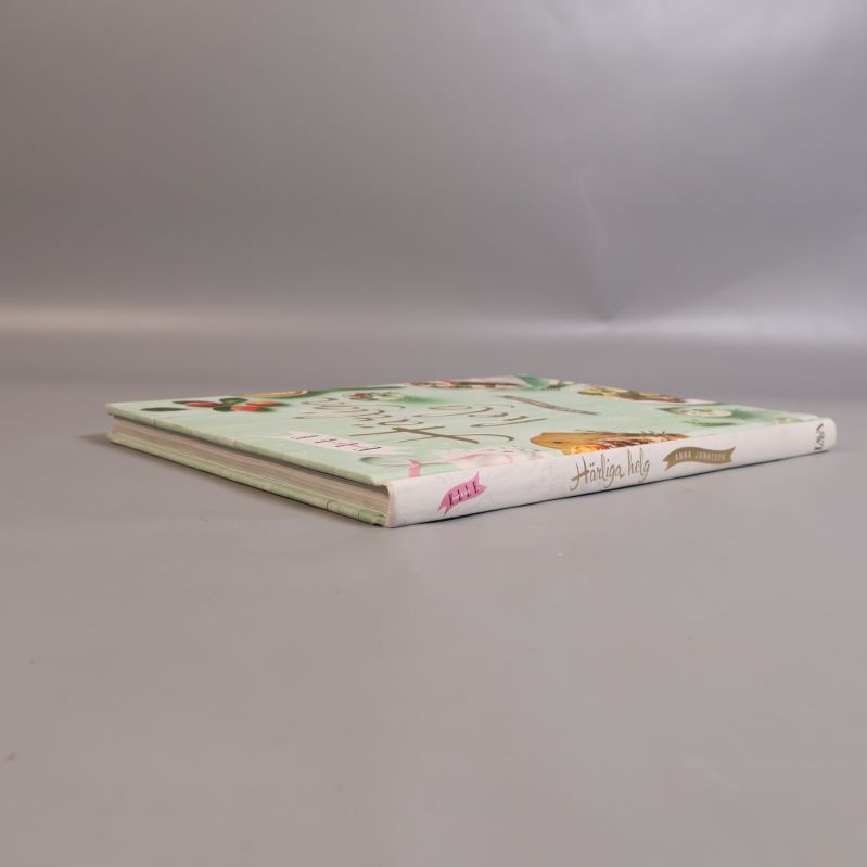 Boken Härliga helg liggande sedd från sidan med ryggtext synlig