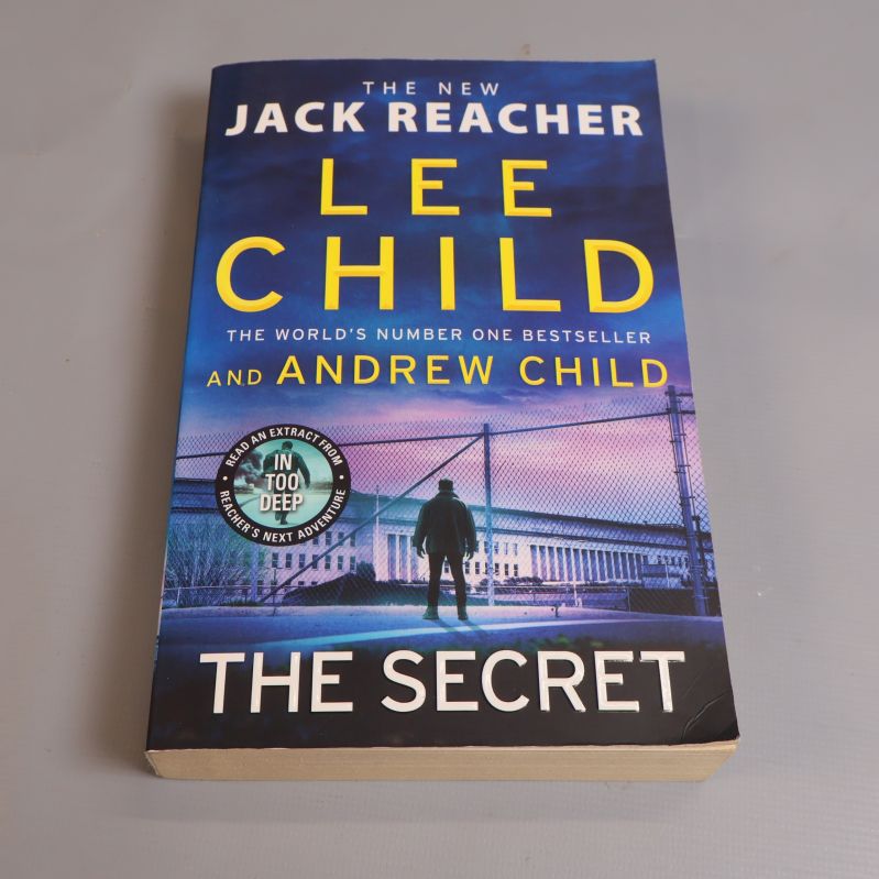 Framsidan av boken The Secret av Lee Child och Andrew Child, blått omslag med siluett