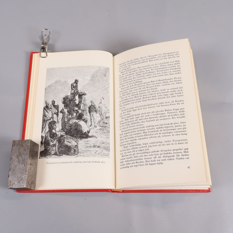 Uppslagen bok med illustration och textsida av Jules Verne
