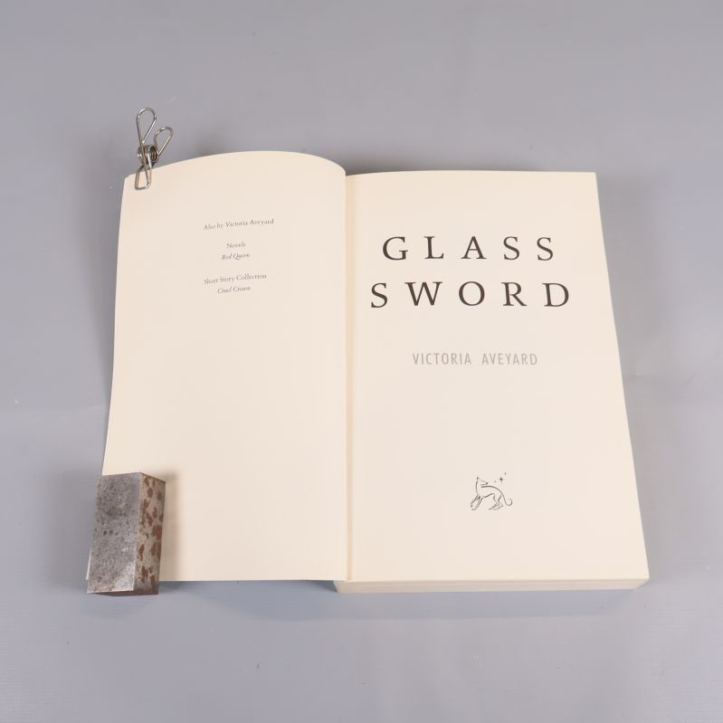 Inslaget uppslag och titelsida till boken Glass Sword av Victoria Aveyard