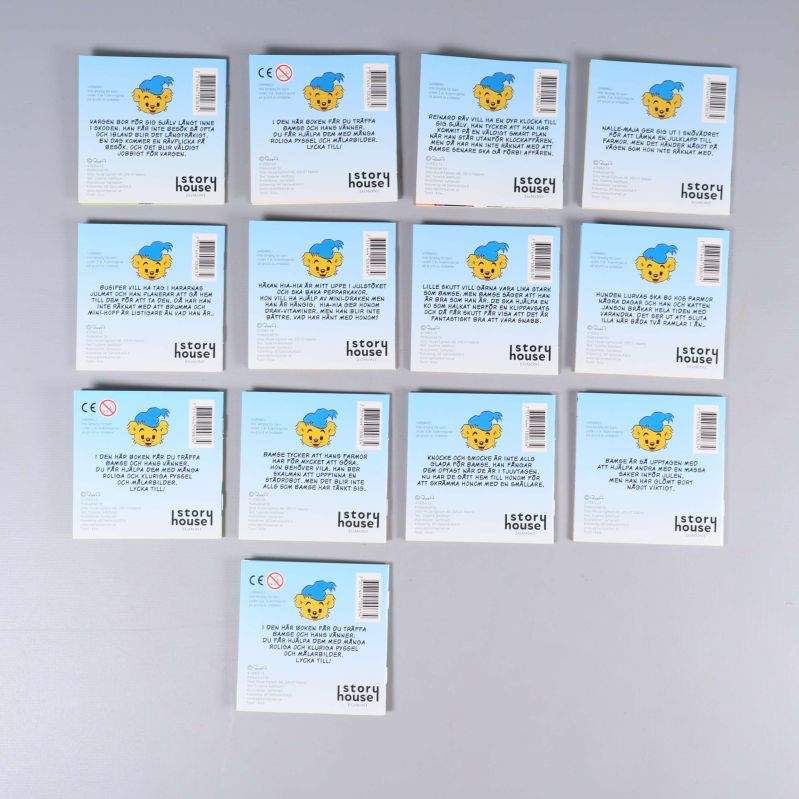 Baksidor av tretton Bamse-böcker med text, CE-märkning och streckkoder synliga