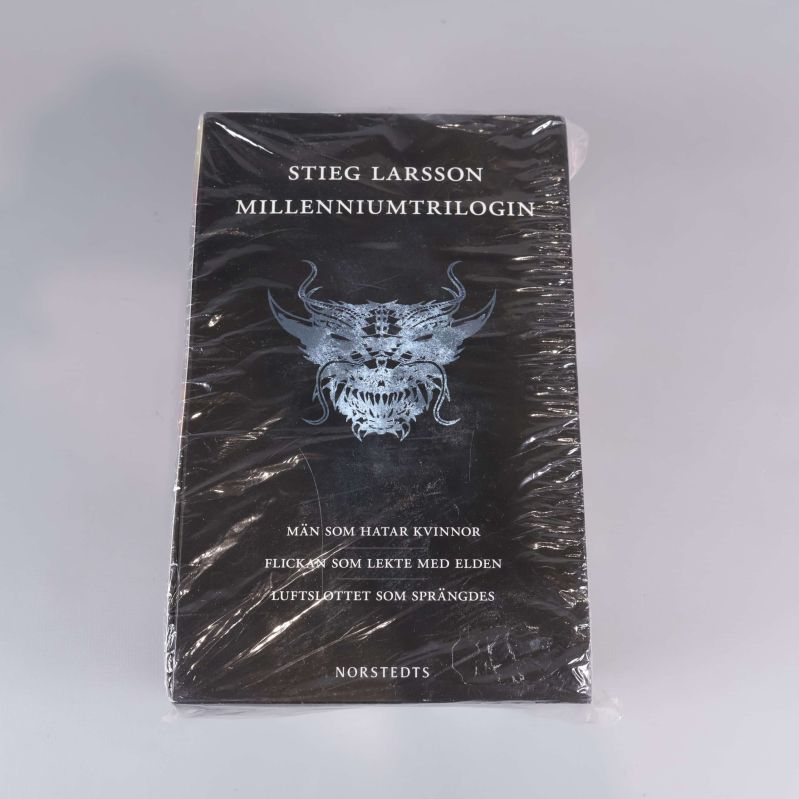 Framsidan av Millenniumtrilogin med drakmotiv och folieeffekt