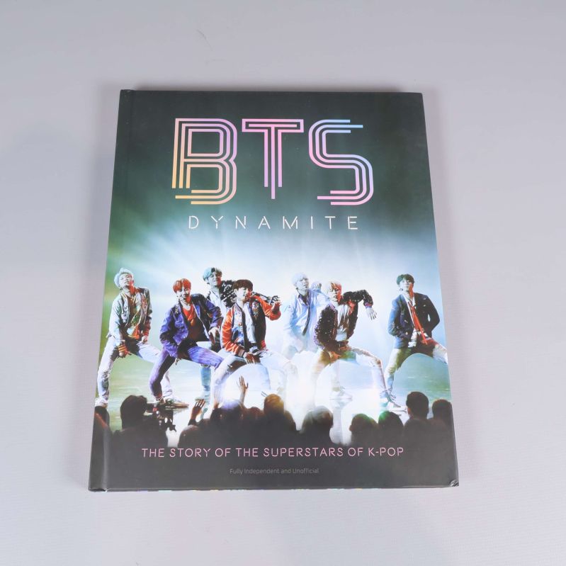 Framsidan av boken BTS Dynamite med gruppen på scenen