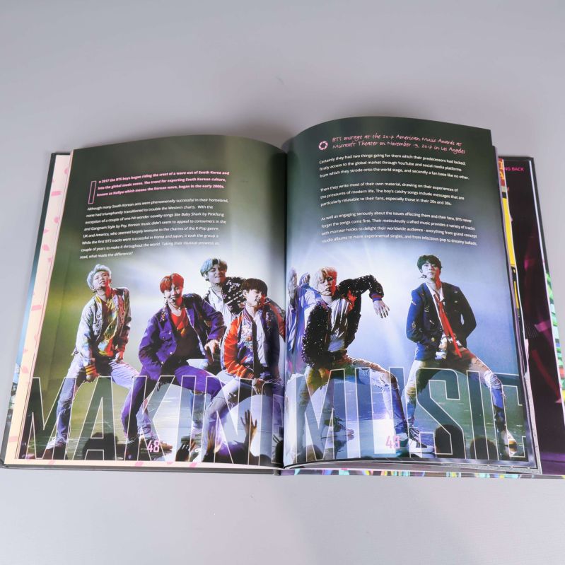 Uppslag med bilder på BTS och engelsk text inuti boken