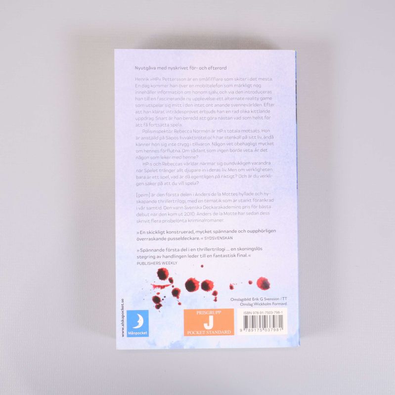 Baksida av Geim med text, recensioner och blodfläckar som designelement