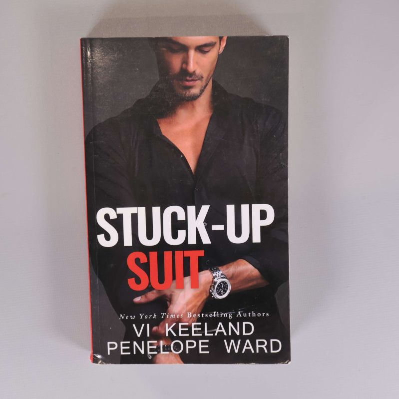 Framsidan av boken Stuck-up suit med svart omslag och röd text