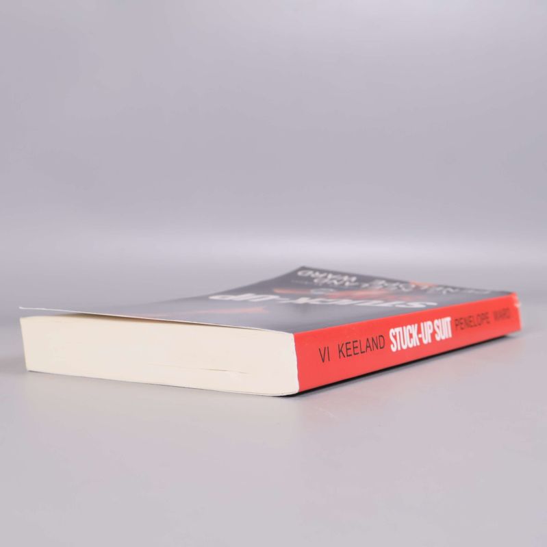 Boken Stuck-up suit liggande snett, visar bokens tjocklek