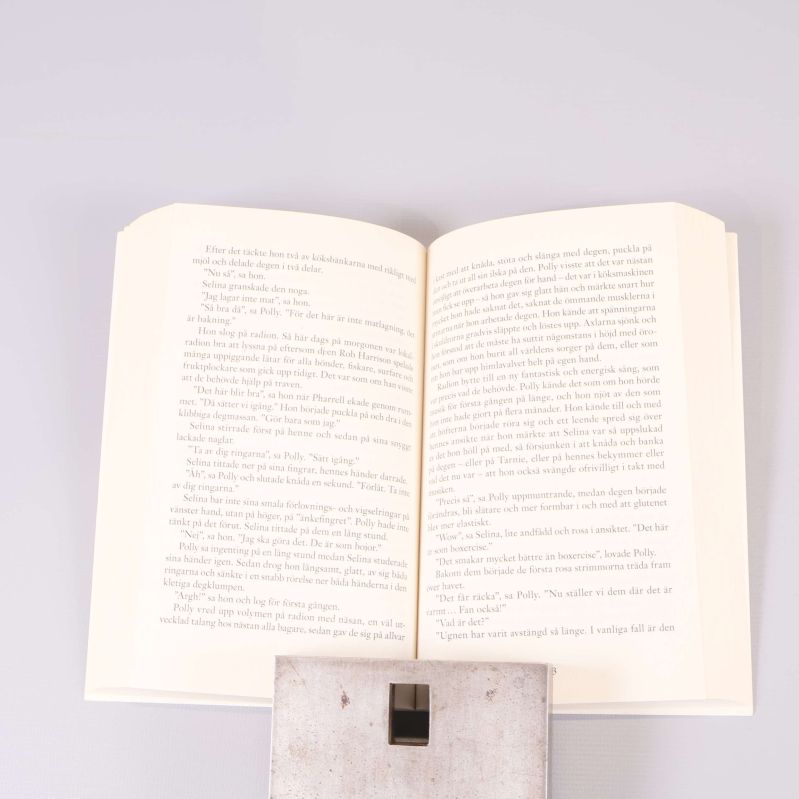Uppslagen pocketbok med svensk text, visar inlaga och sättning