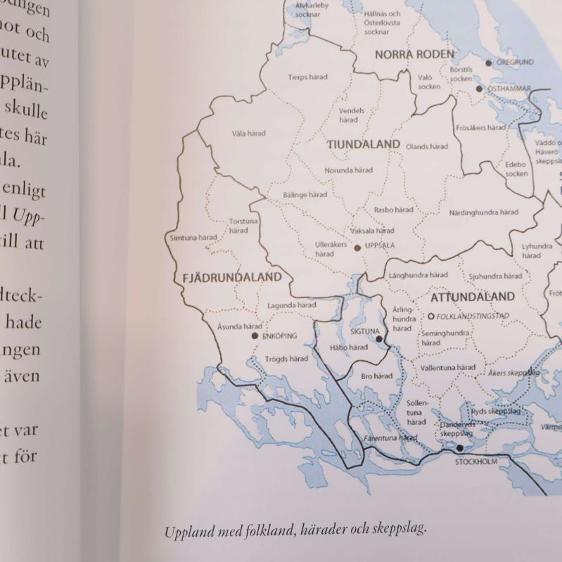 Uppslagen sida med karta över Uppland och dess härader i boken
