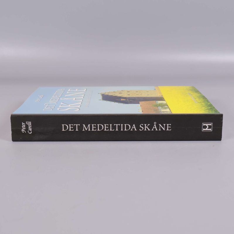 Ryggen av boken Det medeltida Skåne liggande på bord