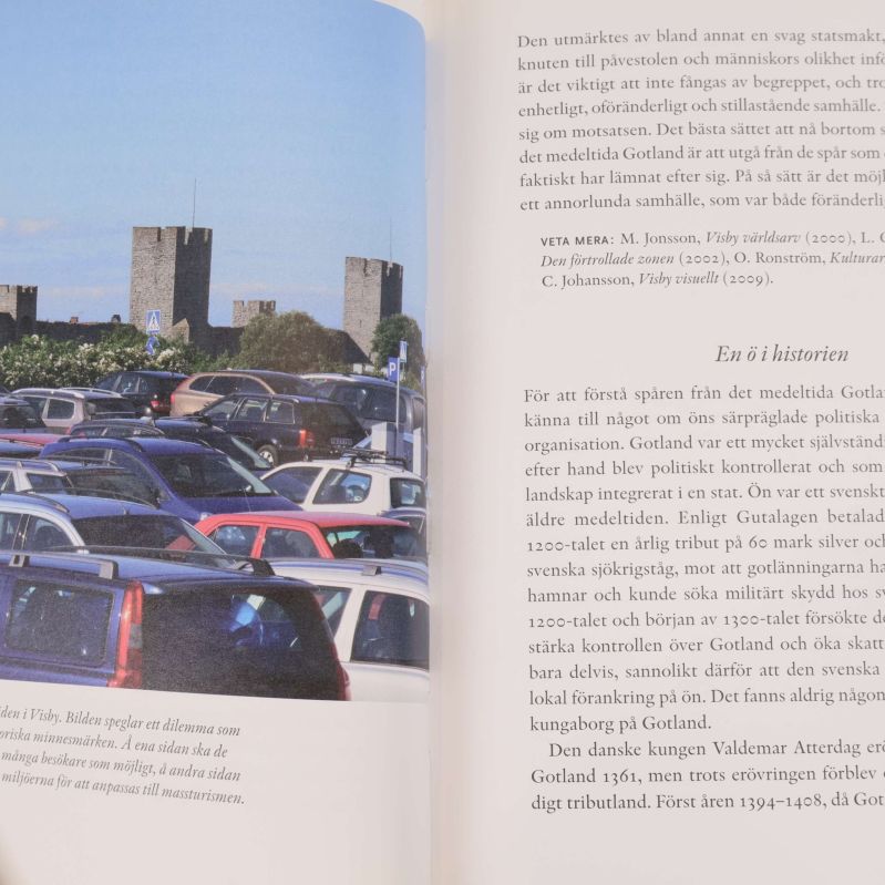Uppslag ur boken med foto på bilar framför Visby ringmur och svensk text