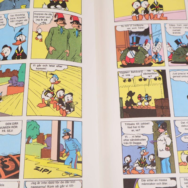 Uppslag med färgglada serierutor av Knatte, Fnatte, Tjatte och Kalle Anka