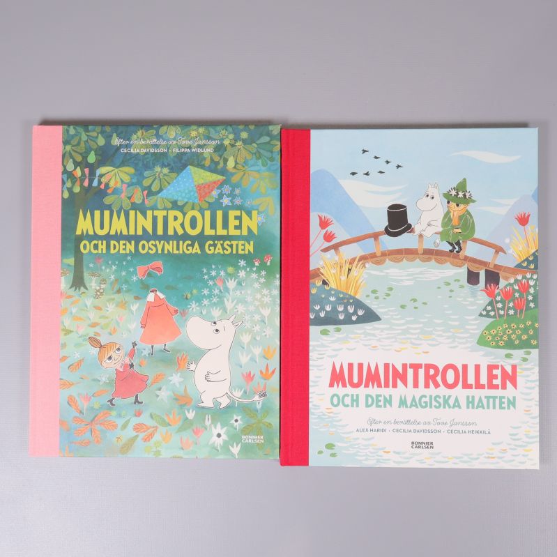 Två Muminböcker med färgstarka omslag och illustrationer