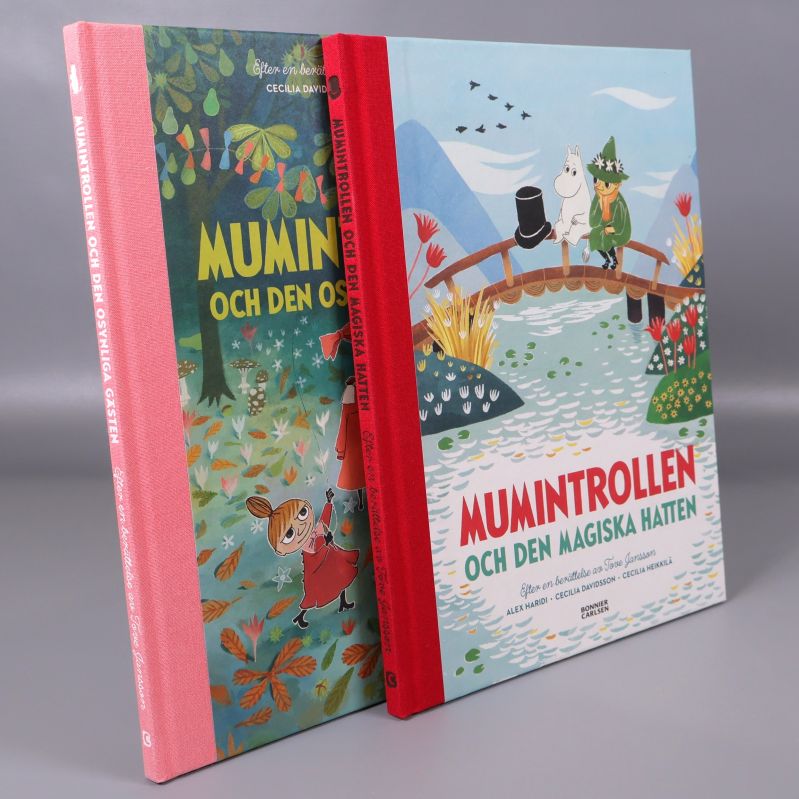 Två Muminböcker stående och lutade mot varandra, visar rygg och omslag