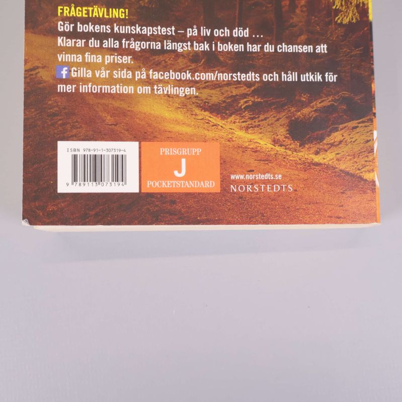 Närbild på baksidan av boken med ISBN och prisgrupp